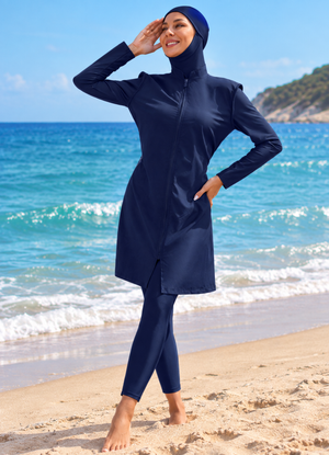 Front view of women's navy full-coverage burkini with hijab and leggings on beach